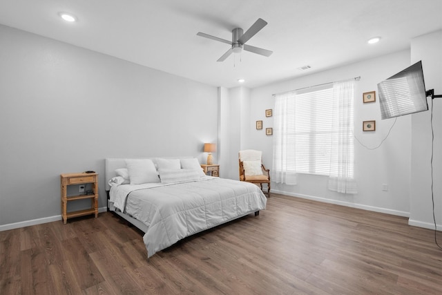 bedroom with baseboards, wood finished floors, and recessed lighting