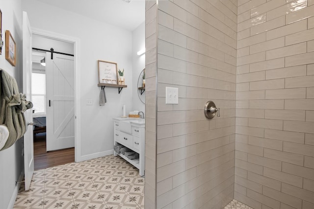 full bathroom featuring tile patterned floors, vanity, baseboards, and tiled shower