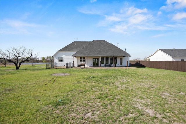 rear view of property with a fenced backyard and a yard