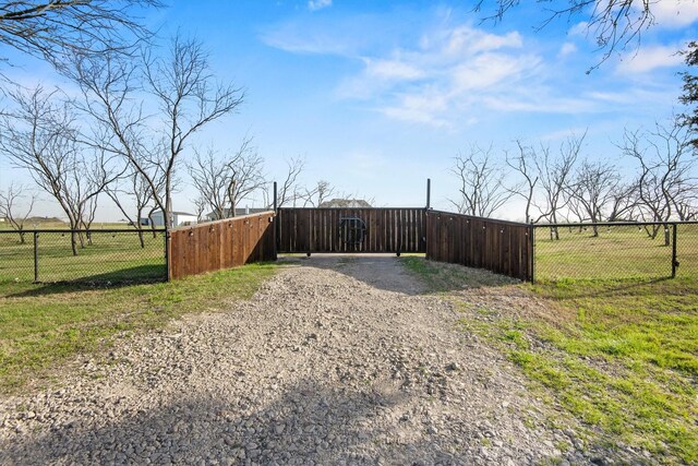 view of yard featuring driveway, a gate, and fence