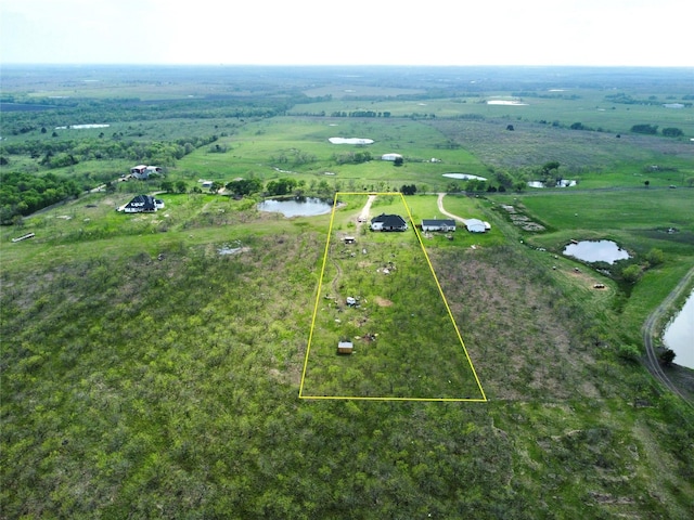 birds eye view of property featuring a water view and a rural view