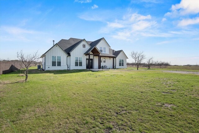 modern inspired farmhouse with fence, board and batten siding, and a front yard
