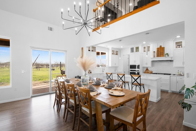 dining room featuring dark wood-style floors, visible vents, an inviting chandelier, and plenty of natural light