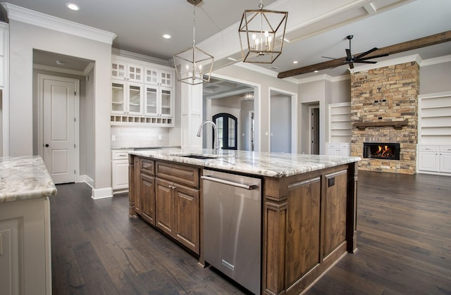 7603 Timber Trl, Tyler, TX 75703 - kitchen with stainless steel dishwasher, a fireplace, a center island with sink, a sink, and a ceiling fan