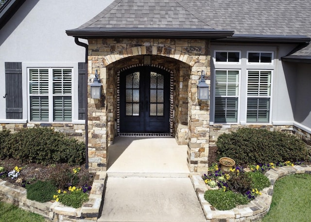 7603 Timber Trl, Tyler, TX 75703 - view of exterior entry featuring stone siding, a shingled roof, french doors, and stucco siding