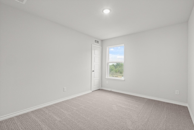 unfurnished room with light carpet, baseboards, and visible vents