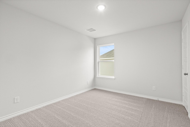 carpeted spare room featuring baseboards and visible vents