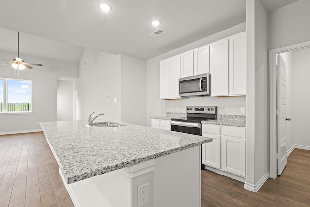 kitchen featuring a sink, light stone countertops, stainless steel appliances, visible vents, and dark wood-style flooring