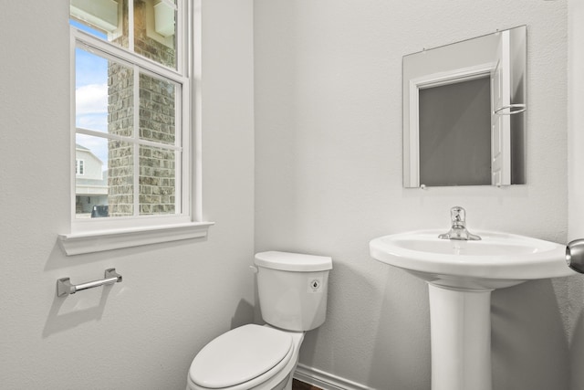 half bath with toilet and baseboards