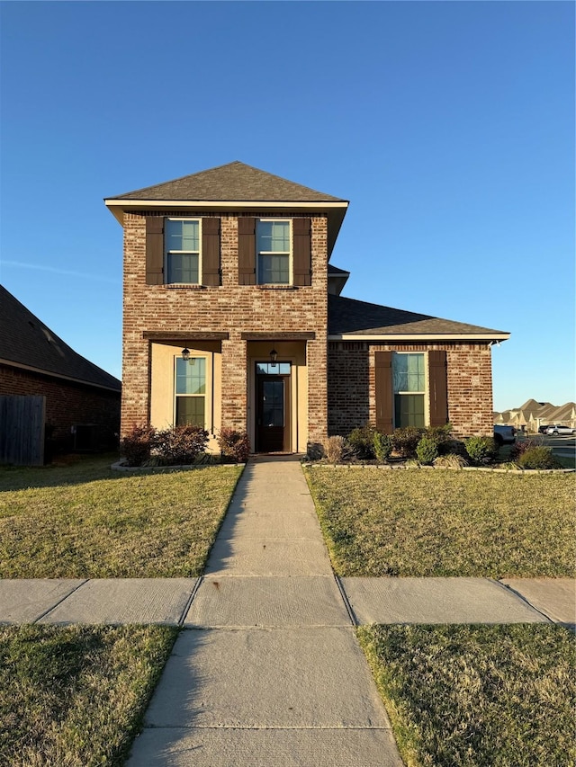traditional-style home featuring brick siding and a front yard