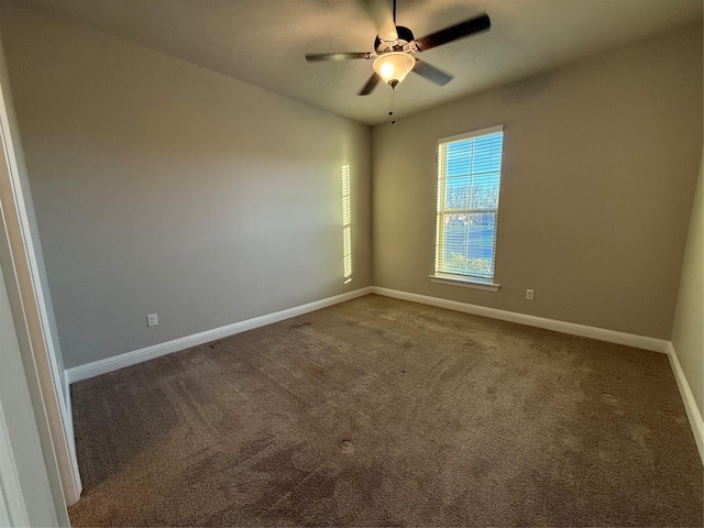 carpeted empty room featuring a ceiling fan and baseboards