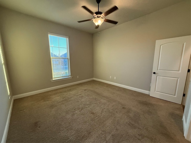 empty room featuring baseboards, carpet floors, and ceiling fan