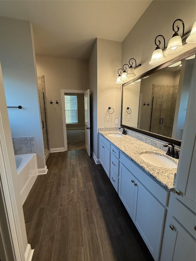full bathroom with a bath, wood finished floors, a sink, and a shower stall