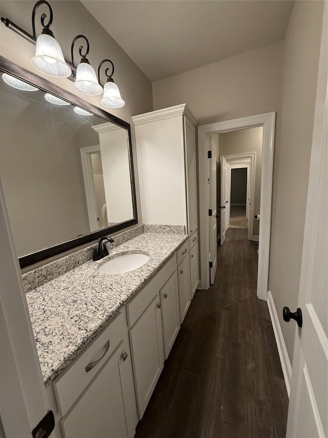 bathroom featuring baseboards, vanity, and wood finished floors