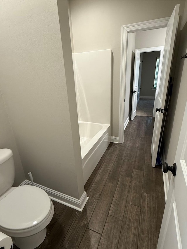 full bathroom with toilet, wood finished floors, and baseboards