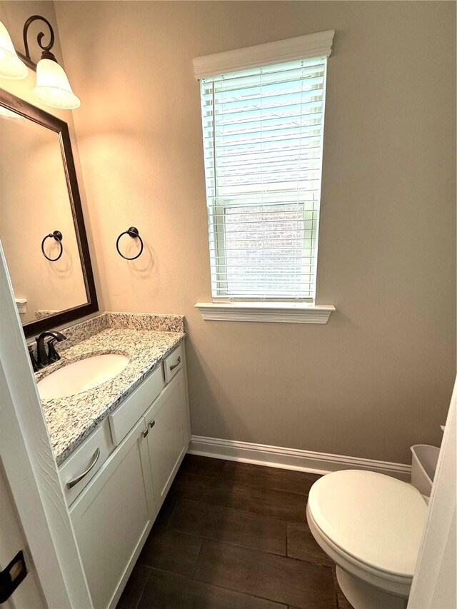 918 Hackberry Dr, Bossier City, LA 71111 - half bathroom with vanity, baseboards, toilet, and wood finished floors