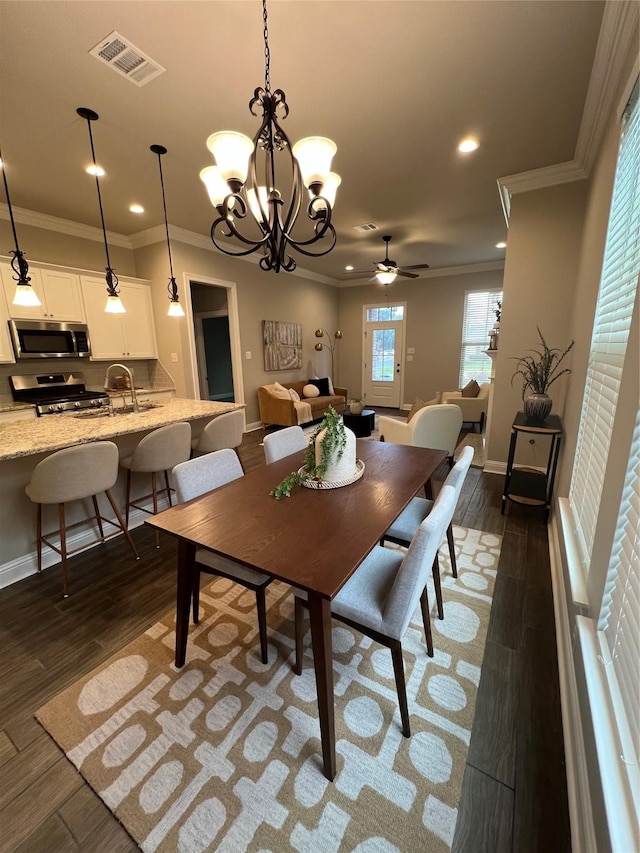 dining room featuring visible vents, recessed lighting, ceiling fan with notable chandelier, dark wood-type flooring, and ornamental molding