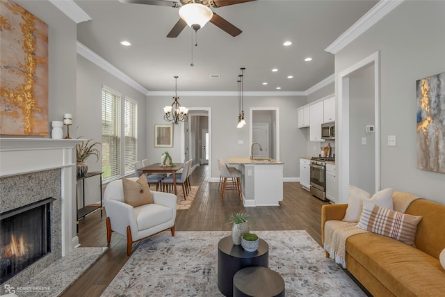 918 Hackberry Dr, Bossier City, LA 71111 - living area with a chandelier, dark wood-style flooring, a fireplace, a ceiling fan, and crown molding