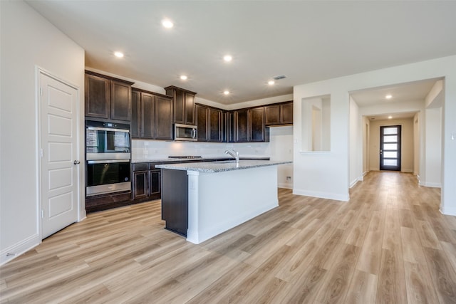 406 Eaton Dr, Justin, TX 76247 - kitchen with dark brown cabinets, gas cooktop, light wood-style floors, stainless steel microwave, and visible vents