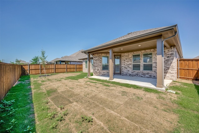 406 Eaton Dr, Justin, TX 76247 - rear view of property with a fenced backyard, brick siding, a patio area, and a lawn
