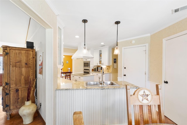 kitchen with visible vents, glass insert cabinets, white cabinetry, a sink, and stainless steel appliances