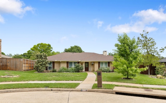 ranch-style house with brick siding, fence, a chimney, and a front lawn