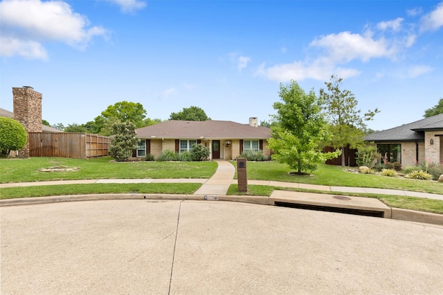 ranch-style house featuring brick siding, fence, and a front yard