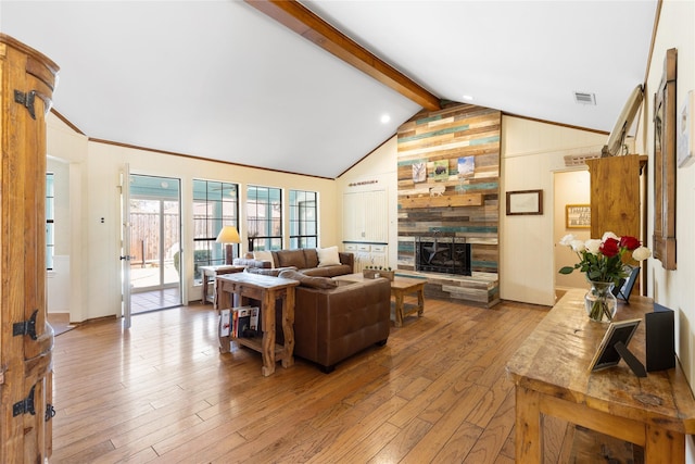 living room featuring visible vents, a fireplace, wood walls, hardwood / wood-style flooring, and vaulted ceiling with beams