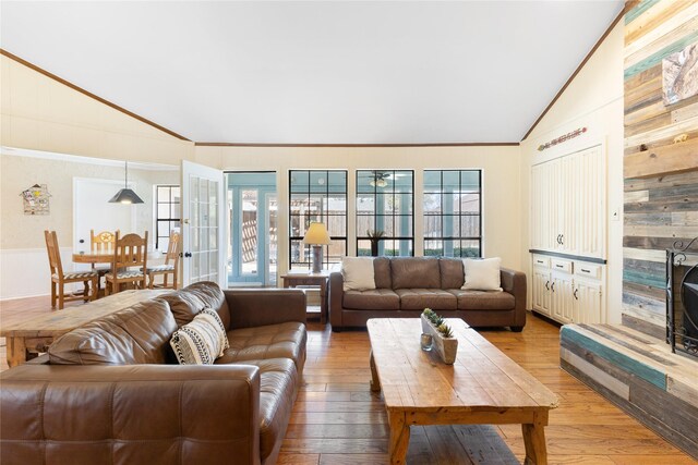 living area featuring crown molding, vaulted ceiling, and plenty of natural light