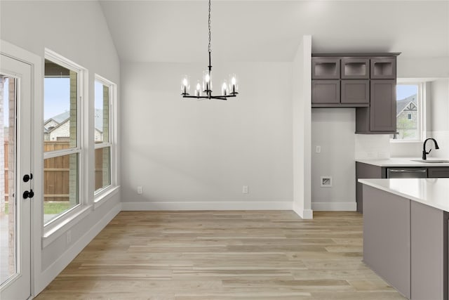 unfurnished dining area with a chandelier, light wood-style floors, and plenty of natural light