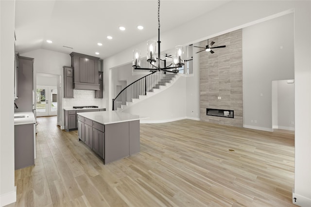 kitchen featuring a center island, gray cabinets, light countertops, and light wood-type flooring
