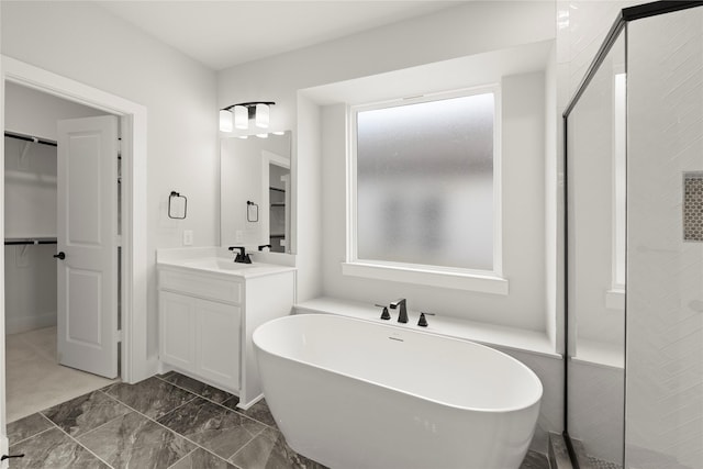 bathroom with a freestanding bath, a spacious closet, tiled shower, and vanity