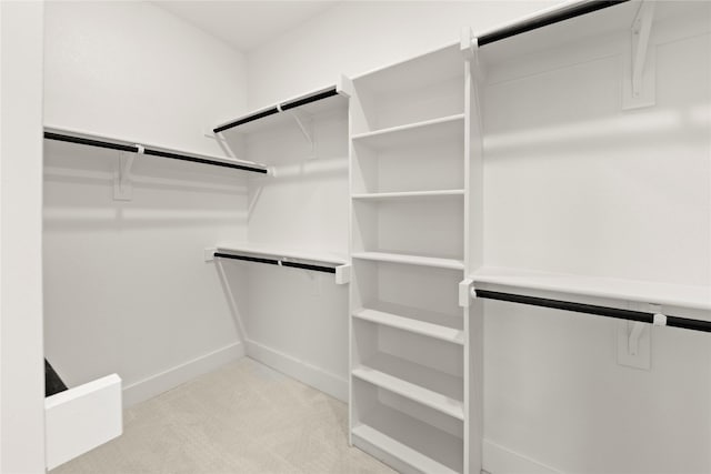 walk in closet featuring light colored carpet