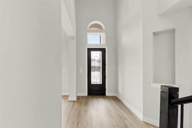 foyer entrance featuring baseboards and light wood finished floors