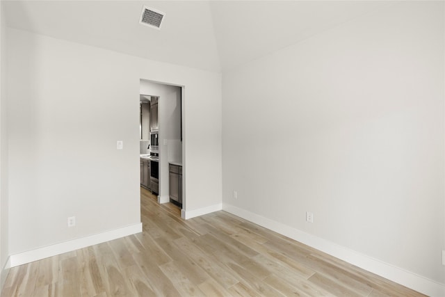 unfurnished room with baseboards, visible vents, and light wood-type flooring