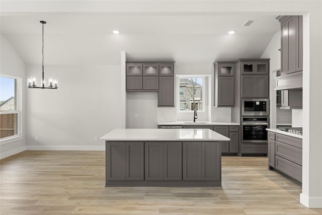 kitchen featuring lofted ceiling, gray cabinets, and appliances with stainless steel finishes