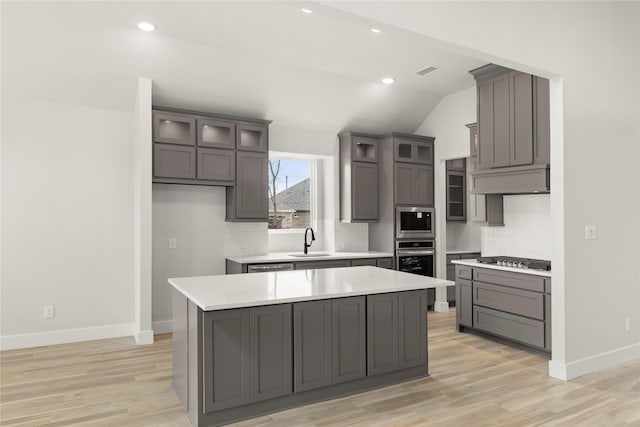 kitchen with light countertops, visible vents, stainless steel appliances, a sink, and light wood-style floors