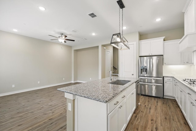 kitchen featuring visible vents, a ceiling fan, wood finished floors, a sink, and appliances with stainless steel finishes