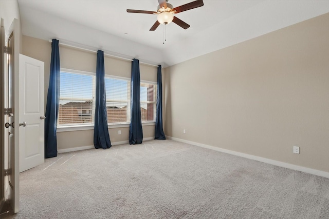 carpeted spare room with ceiling fan and baseboards