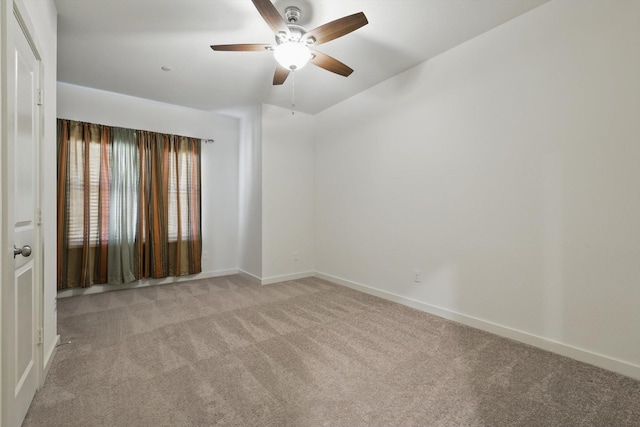 carpeted empty room with ceiling fan and baseboards