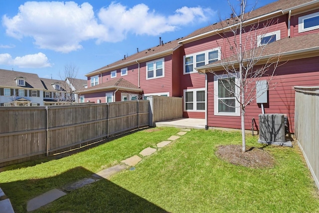view of yard with a residential view, fence, and central AC unit