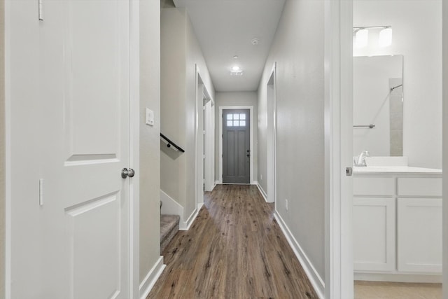 doorway featuring baseboards and wood finished floors