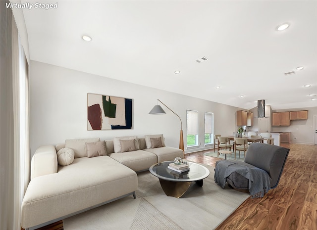 living room with recessed lighting, light wood finished floors, and visible vents