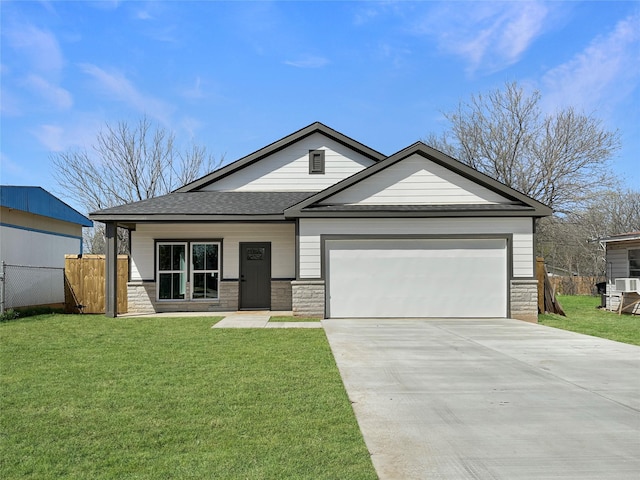 view of front of home with driveway, an attached garage, fence, and a front yard