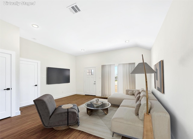 living area with vaulted ceiling, wood finished floors, baseboards, visible vents, and recessed lighting
