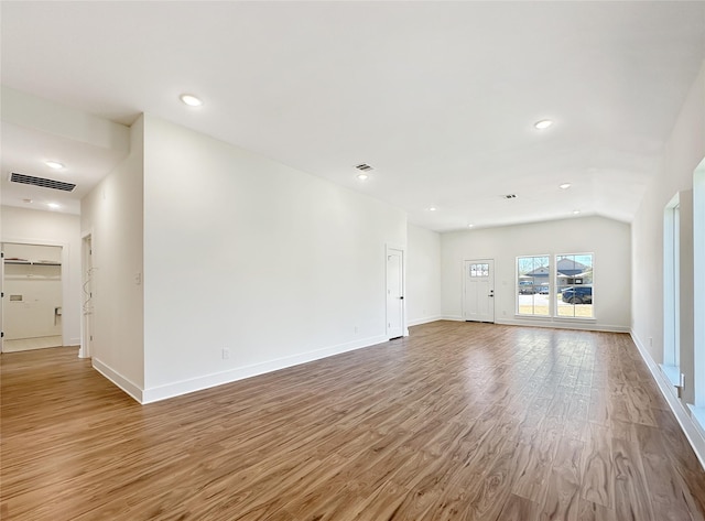 unfurnished living room featuring baseboards, visible vents, wood finished floors, and recessed lighting
