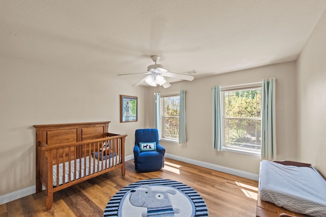 4167 Prairie Meadow Ct, Fort Worth, TX 76244 - bedroom with wood finished floors, baseboards, a crib, and a ceiling fan