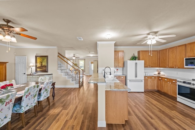 4167 Prairie Meadow Ct, Fort Worth, TX 76244 - kitchen with white appliances, ceiling fan, a sink, a peninsula, and wood finished floors