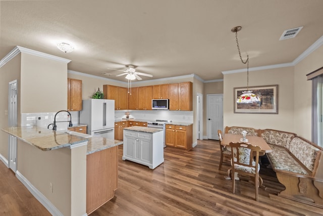 4167 Prairie Meadow Ct, Fort Worth, TX 76244 - kitchen featuring stainless steel microwave, freestanding refrigerator, gas range, dark wood-style flooring, and a peninsula
