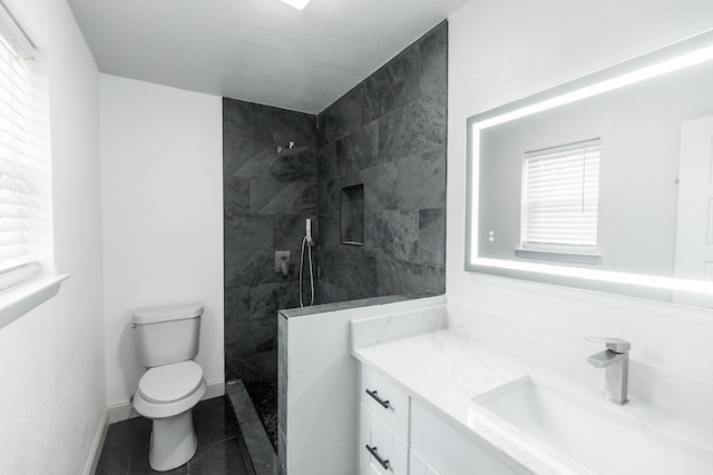 full bath featuring baseboards, toilet, tile patterned floors, vanity, and a walk in shower